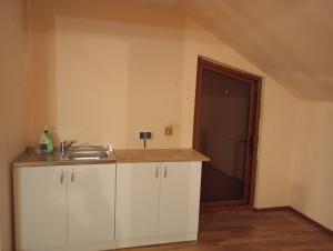 een keuken met witte kasten en een spoelbak bij Central Rooms Craiova in Craiova