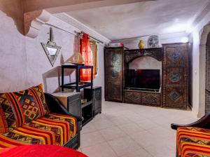 a living room with a couch and a television at Belle Maison Taghazout in Taghazout