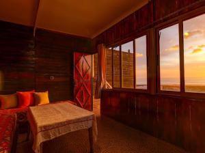 a bedroom with a bed and windows with a view at Belle Maison Taghazout in Taghazout