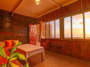 a room with a bench and a room with windows at Belle Maison Taghazout in Taghazout
