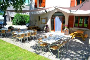 a group of tables and chairs in front of a building at Auberge La Cure in Oz