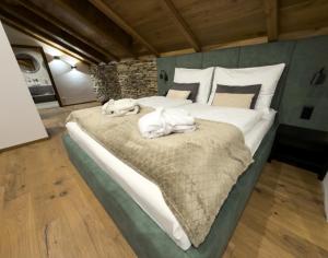 ein Schlafzimmer mit einem großen Bett, auf dem Handtücher liegen in der Unterkunft Vila Vento in Veľký Slavkov