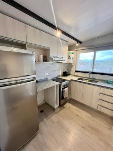 a kitchen with stainless steel appliances and a large window at Moderno DEPARTAMENTO temporal SAN JORGE in San Jorge +1 photo