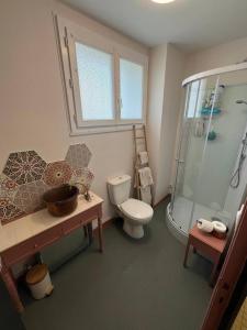 een badkamer met toilet en glazen douche bij Cabane Feuille - Glamping on a vineyard - Wooden Cabin in Savigné