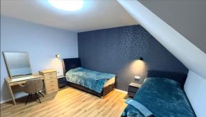 a bedroom with two beds and a desk and a chair at Schöne Ferienwohnung in Schwerte Central in Schwerte