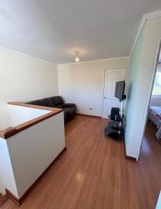 an empty living room with a couch and a television at Departamento Luciana in Coquimbo