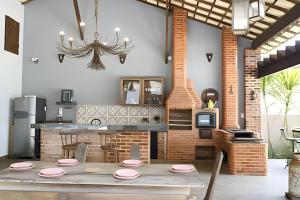 a dining room with a table and a kitchen at Casa Rústica - Próx à Praia in Saquarema