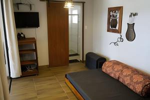 a living room with a couch and a television at Casa Rústica - Próx à Praia in Saquarema