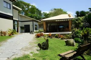 a house with a yard with a bench in front of it at Casa Rústica - Próx à Praia in Saquarema