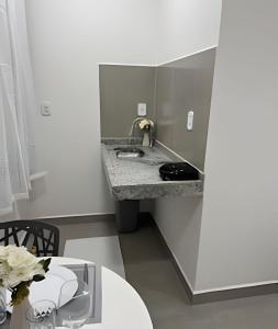 eine Küche mit einem Waschbecken und einem Tisch in der Unterkunft Suíte aconchegante a 3 min da Praia do Pontal! (3) in Arraial do Cabo + 8 Fotos