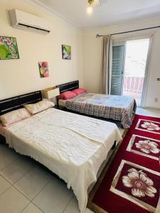 zwei Betten in einem Zimmer mit Fenster in der Unterkunft شاليه للايجار غرفتين مارينا 7 in El-Alamein