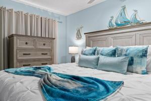 una camera da letto con un letto con una coperta blu sopra di Hello Sunshine at Sandpiper Cove a Destin