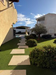 een tuin met een pad naar een huis bij Appartamento Sardinia Escape in residence - Palau in Palau