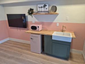 een keuken met een aanrecht met spoelbak en magnetron bij Abode Beach House in Clearwater Beach
