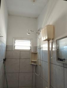 La salle de bains est pourvue d'une douche et d'une fenêtre. dans l'établissement Suite Big Tower, à Penha