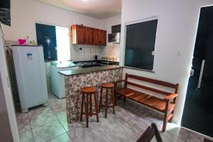 a kitchen with a bench and a counter with a stove at Apartamento da Joana - 2ª Praia, Morro de SP in Morro de São Paulo