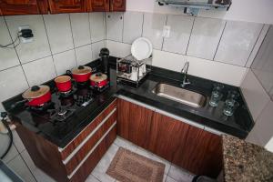 a small kitchen with a stove with pots and pans at Apartamento da Joana - 2ª Praia, Morro de SP in Morro de São Paulo +22 photos
