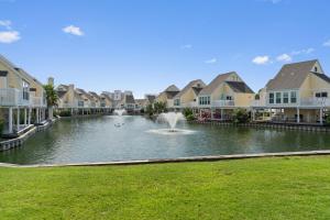 una fontana in uno stagno di fronte ad alcune case di Hello Sunshine at Sandpiper Cove a Destin