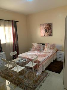 una camera da letto con un letto, un tavolo e delle sedie di Keur Antou a Dakar