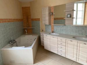 ein Badezimmer mit zwei Waschbecken und einer Badewanne in der Unterkunft maison de ville dans le perche in Senonches + 26 Fotos