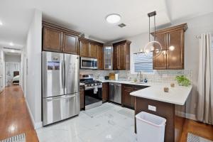 a kitchen with wooden cabinets and stainless steel appliances at 4 BR • Vaulted Living • Sleeps 11 in Jersey City
