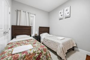 two beds in a room with white walls at 4 BR • Vaulted Living • Sleeps 11 in Jersey City
