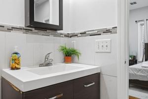 a bathroom with a white sink and a bedroom at 4 BR • Vaulted Living • Sleeps 11 in Jersey City +20 photos
