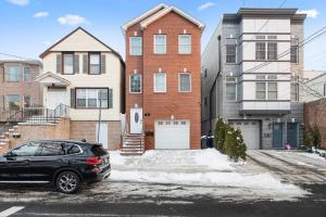 a black car parked in front of a house at 4 BR • Vaulted Living • Sleeps 11 in Jersey City