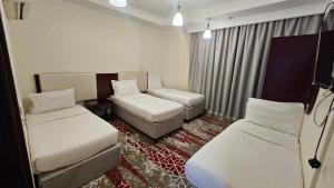 una piccola stanza con due letti e un divano di فندق ربوة الصفوة ريع بخش a Ajyad