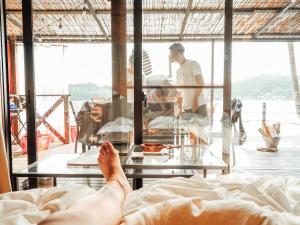 MatsuuraGlamping village Seagrand的躺在床上的人,脚踏在桌子上