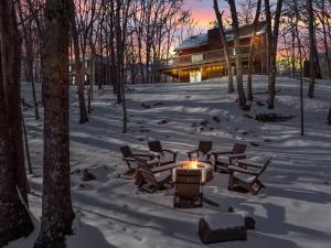 a fire pit in the snow in front of a house at LUX Lakefront, Pool, Hot Tub, Game Room, FIFA 2026 in Bushkill