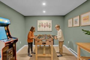 two people playing chess in a room with a video game at LUX Lakefront, Pool, Hot Tub, Game Room, FIFA 2026 in Bushkill +137 photos