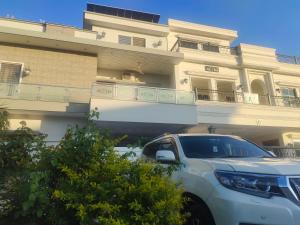 a white truck parked in front of a building at Komal Residency in Islamabad