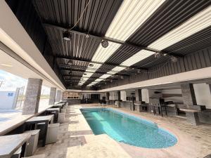 a swimming pool in a building with tables and chairs at Hotel Las Vegas in Matamoros