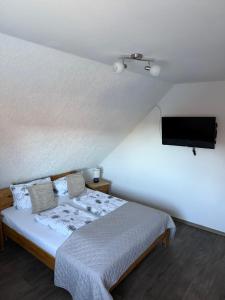 une chambre avec un lit et une télévision à écran plat dans l'établissement Ferienwohnungen Avenor, à Norden