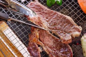 MatsuuraGlamping village Seagrand的烤架上放着一把刀，刀尖抵着一块肉