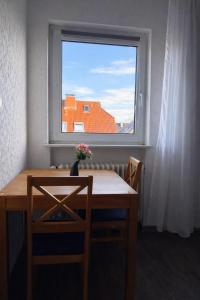 une table et des chaises dans une pièce avec une fenêtre dans l'établissement Ferienwohnungen Avenor, à Norden