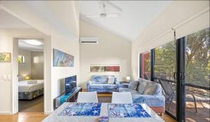 a living room with a couch and a table at Relaxing Beach shack at the Footprints complex in Preston Beach +25 photos