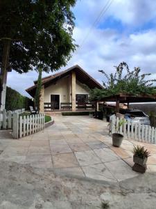 a white picket fence in front of a building at Chalé 4 Quartos Casa Jasmin in Chã Grande
