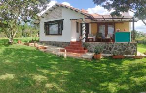 a small house with a green lawn in front of it at Hospedaje Rural Pistacia Vera - Villa de Leyva in Villa de Leyva
