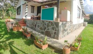 a house with a stone retaining wall and potted plants at Hospedaje Rural Pistacia Vera - Villa de Leyva in Villa de Leyva