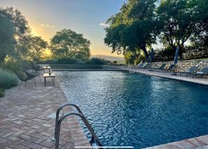 a swimming pool with chairs and a table next to it at Cortijo Bablou in Arcos de la Frontera