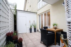 a patio with a table and chairs and plants at _ARW3_ _ Ferienwohnung Kossmann in Niendorf