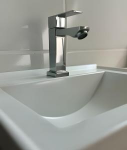 un lavandino con rubinetto in bagno di Loft das Esrelas c/Ar p/4 a Volta Redonda