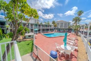 een balkon met uitzicht op het zwembad van een resort bij Abode Beach House in Clearwater Beach