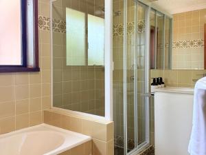 a bathroom with a shower and a sink and a tub at Leski Club in Jindabyne +67 photos