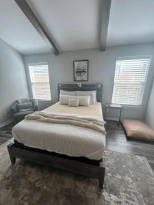 a bedroom with a large bed and two windows at NWA Modern Stay in Springdale
