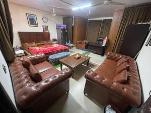 ein Wohnzimmer mit Ledermöbeln und einem Bett in der Unterkunft Secure Private Apartment Privacy Guaranteed in Lahore
