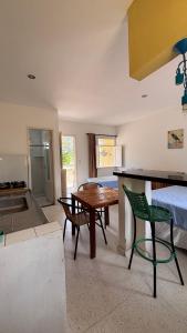 ein Wohnzimmer mit Tisch und Bett in der Unterkunft Chalé Pitaya 05 in Piranhas