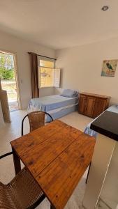 ein Schlafzimmer mit zwei Betten und einem Holztisch in der Unterkunft Chalé Pitaya 05 in Piranhas + 3 Fotos